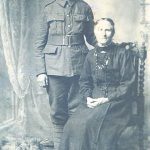 A photograph of Ernest Gurden standing by his mother