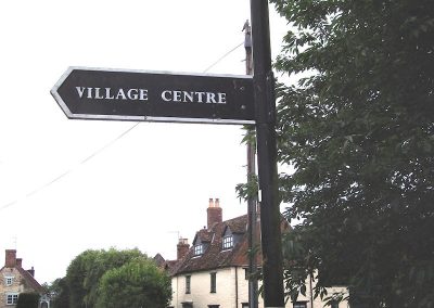 Signpost to the village centre with the Crown Inn in the background, by Alison Biddle